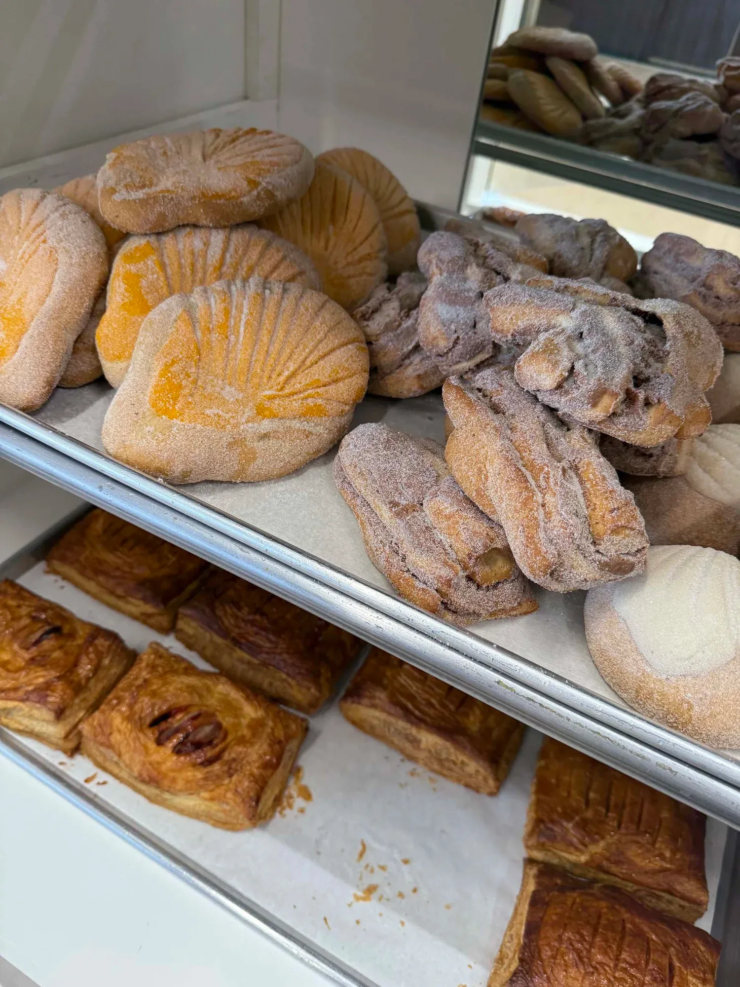 Charolas llenas de pan dulce dorado en el mostrador de La Esperanza