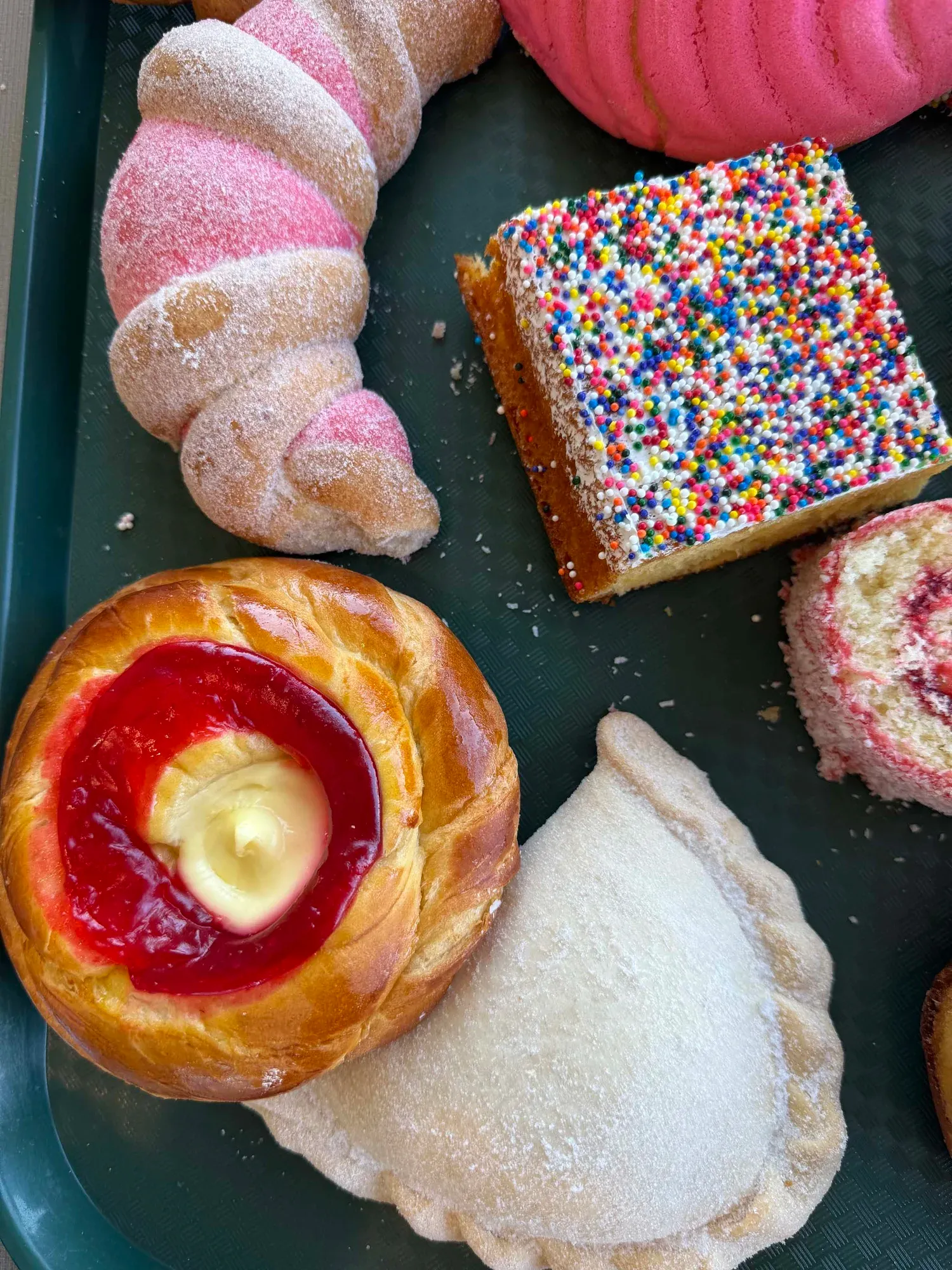 Empanada cubierta de azúcar en una charola de pan dulce